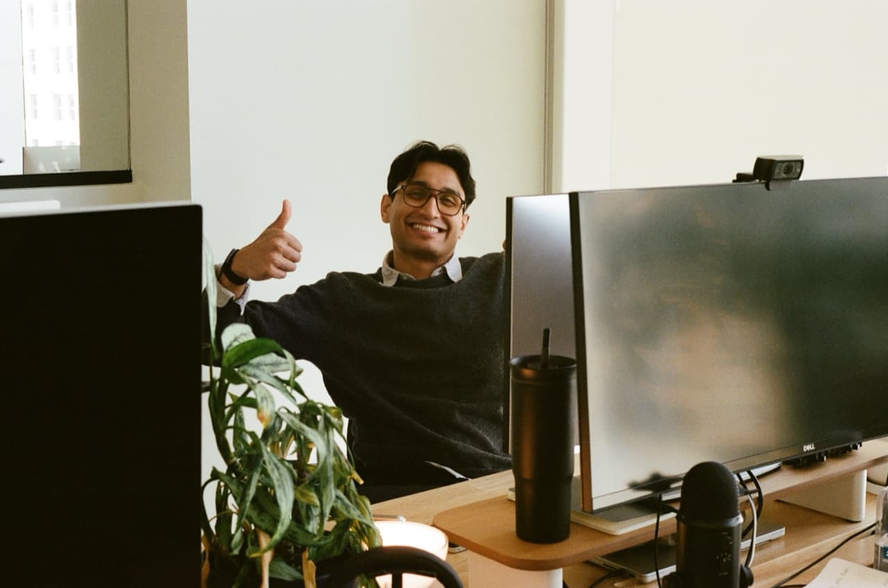A teammate giving a thumbs up between monitors.